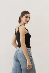 Musculosa negra de tirantes finos con detalles translúcidos en los bordes y diseño ajustado al cuerpo.