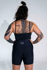 Calza biker deportiva de tiro alto, color negro, confeccionada en tejido técnico elástico con logo pequeño estampado en el ruedo.
