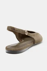 Zapato plano tipo destalonado confeccionado en serraje, con diseño de punta fina y tira trasera ajustable con hebilla metálica.