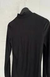 Vestido corto negro de cuello alto y manga larga, confeccionado en tejido ajustado al cuerpo.