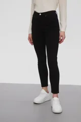 Pantalon de jean negro, corte skinny y tiro medio, con cierre frontal y bolsillos laterales.