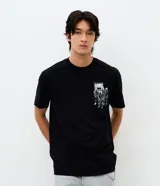 Remera de algodón color negro, de corte relajado y manga corta. Presenta un diseño estampado en la espalda con el logo de la banda Ramones y una ilustración temática de Rockaway Beach en color blanco.