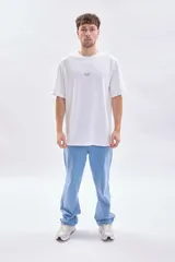 Remera de corte oversize color blanco, con cuello redondo y estampa pequeña con texto en el centro del pecho.