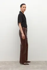 Pantalón de ecocuero color chocolate con textura de cocodrilo, de corte recto y tiro alto.