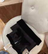 Conjunto de accesorios de invierno compuesto por un cuello envolvente y un par de mitones, ambos confeccionados en cuero napalan negro con interior de piel sintética.