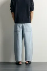 Jeans tapered wide fit de hombre, confeccionados en denim de algodón con efecto lavado en tono azul oscuro. Presentan diseño de cinco bolsillos, tiro medio, corte relajado y cierre frontal con cremallera y botón.