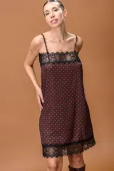 Vestido lencero de satén con estampado de lunares, breteles finos regulables y detalles de puntilla negra en el escote y el ruedo.