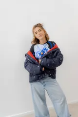 Campera puffer azul marino con estampado de motivos náuticos en blanco, rojo y verde.