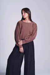 Blusa negra de mangas largas abullonadas y cuello redondo.