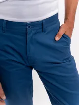 Pantalon chino de corte regular y tiro medio, con cierre de boton y cremallera, bolsillos laterales y traseros, y terminacion recta.