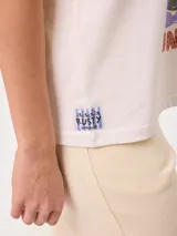 Remera de algodón marca Rusty, color blanco, de corte holgado, con cuello redondo, mangas cortas y estampado frontal colorido de temática tropical.