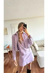 Camisa de cuero ovino desgastado color lila, con escote en V y cordones cruzados en el centro. Presenta mangas largas con recortes y cordones decorativos a lo largo de los brazos.