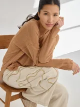 Pantalon de corte recto y tiro medio, color beige, con bordados artesanales en hilo que simulan vetas. Confeccionado en una mezcla de algodón, viscosa y lino.
