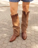 Bota alta de cuero y gamuza color marrón, con diseño 2 en 1 que incluye estribo desmontable, taco cuadrado y punta cuadrada.