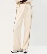 Pantalón de corte recto color negro con tiras laterales blancas en contraste. Cuenta con cintura elástica y cordón ajustable.