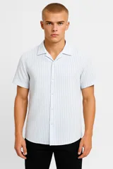 Camisa de algodón a rayas verticales celestes y blancas, con cuello camisero y botones.