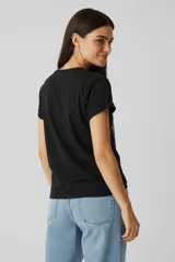 Remera de manga corta con cuello redondo, diseño holgado y estampado frontal de estrella con efecto foil y frase.