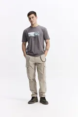 Remera de manga corta color gris oscuro con cuello redondo y un estampado rectangular frontal que simula una obra de arte paisajística en blanco y negro.