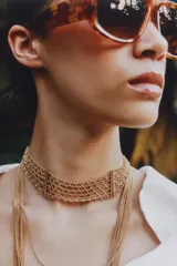 Pack de dos collares dorados de múltiples cadenas finas, compuesto por un choker rígido de eslabones entrelazados y un collar largo de varias tiras en cascada con cierre de mosquetón.