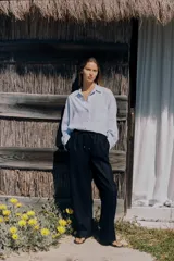 Pantalón azul marino de lino, de tiro alto con cintura elástica ajustable con cordones, bolsillos delanteros y pernera recta.