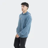 Canguro Reef con capucha, confeccionado en tejido con efecto lavado color gris oscuro. Presenta un estampado gráfico pequeño en el centro del pecho con diseño de cuadros en tonos rojos y azules, y bolsillo frontal tipo canguro.