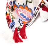 Pashmina de gasa sintética liviana con estampado floral multicolor y terminación en flecos con borlas rojas.