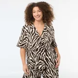 Blusa de punto crepé con estampado animal print tipo cebra en tonos marrón y crema. Presenta cuello solapa, cierre frontal con botones y mangas cortas de corte holgado.