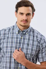 Camisa de manga corta con estampado de cuadros en tonos azules, rojos y blancos, cuello con botones y bolsillo ojal en el pecho con logo bordado.