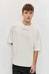 Remera marrón oversize de manga corta, con cuello redondo y pequeños estampados blancos en el pecho.