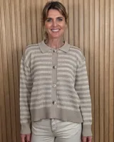 Cardigan de punto color marrón tostado, con cuello camisero, cierre frontal con botones y diseño de rayas sutiles en el tejido. Presenta mangas largas con puños elásticos y corte recto.