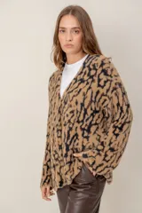 Cárdigan de punto con textura suave, estampado animal print en tonos marrones y negros, con escote en V y cierre frontal.