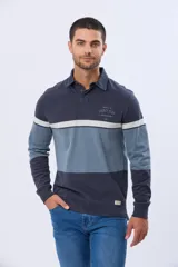 Remera polo de manga larga con diseño de bloques de color horizontales en tonos azul, verde y marrón. Presenta cuello clásico, cierre frontal con botones y bordado en el pecho. Cuenta con puños elásticos acanalados.