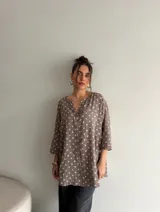 Blusa de viscosa con estampado de lunares, corte holgado, mangas tres cuartos y escote en V con botón central.