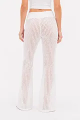 Pantalón de tiro alto y diseño ancho, confeccionado en tejido de punto crochet de color blanco.
