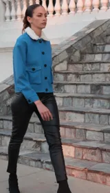 Campera azul con cuello de piel sintética desmontable, cierre con botones, bolsillos con solapa y puños con botón.