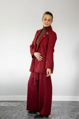 Blazer de lana con estampado de cuadros vichy en tonos rojo y marrón, solapas clásicas, dos bolsillos delanteros y cierre frontal de botones.
