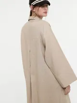 Vestido camisero oversized color beige, confeccionado en 83% ramié y 17% algodón, con mangas amplias, puños altos y cartera con botones delanteros.