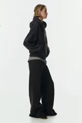 Pantalón deportivo de felpa en color negro, con diseño de pierna levemente acampanada. Presenta cintura elástica con cordón de ajuste y un interior cepillado suave.