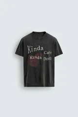Camiseta de manga corta y cuello redondo, color negro con efecto lavado. Presenta un estampado frontal con un corazón rojo y texto en blanco que dice "Kinda Care Kinda Don't".