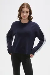 Sweater de tejido jacquard color azul marino, con cuello redondo y diseño holgado. Presenta franjas laterales en color gris claro a lo largo de las mangas largas.