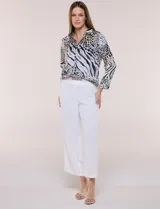 Blusa de gasa liviana con estampado animal print que combina leopardo y cebra, cuello camisero con escote en V y mangas largas con puños anchos.