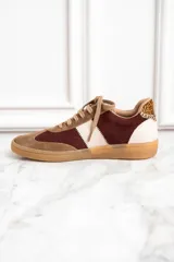 Zapatillas deportivas marrones con detalles en color borgoña y blanco, con cordones y suela de goma.