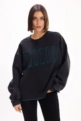 Buzo oversize color marrón con cuello redondo, mangas largas amplias y puños acanalados. Presenta letras en relieve con efecto desflecado en el frente y ruedo con terminación desflecada.