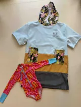 Poncho de toalla con capucha, diseño color block en celeste, amarillo y gris. Capucha con estampado floral.