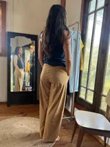 Pantalón tiro medio color tostado, confeccionado en plush de algodón, de corte recto y holgado. Cuenta con faja ancha en la cintura para mayor sostén y bolsillos delanteros aplicados.