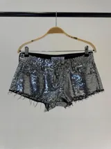 Short de tiro bajo confeccionado en tela cubierta de lentejuelas plateadas, con diseño de cinco bolsillos y ruedo deshilachado.