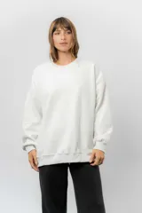 Buzo oversize de cuello redondo, confeccionado en algodón suave con interior frizado. Presenta un diseño de líneas simples, corte relajado y mangas largas con puños ajustados.