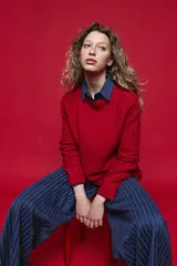 Sweater de tejido de punto negro con tramas de ochos en las mangas y laterales, cuello redondo a la base y mangas largas.
