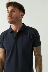 Remera polo blanca de manga corta, con cuello clásico, cierre de tres botones y logo estampado en el pecho.