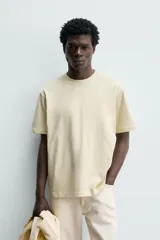 Camiseta regular fit de color beige, confeccionada en tejido de algodón compacto, con cuello redondo y manga corta.